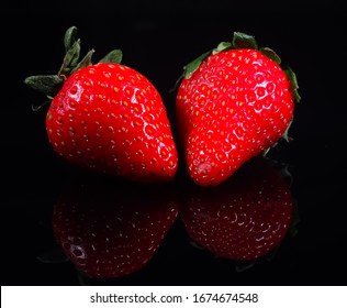 Delicious Strawberries On A Black Reflective Surface.