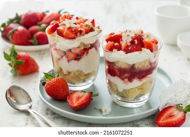 delicious strawberry vanilla cream dessert in glasses served with fresh berries, white background