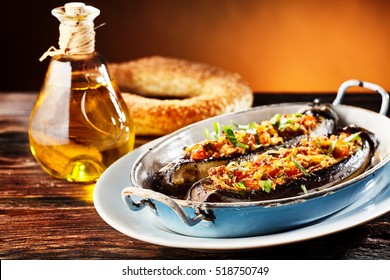 Delicious Stuffed Fresh Brinjal, Aubergine Or Eggplant With A Savory Spicy Veggie Stuffing Served In A Metal Dish With A Pretzel And Olive Oil