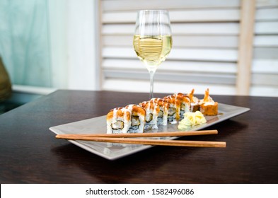 Delicious sushi served on a plate with white wine