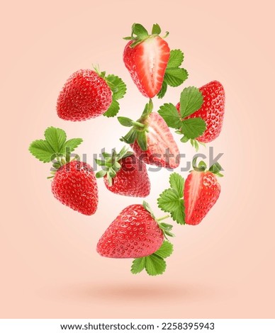 Delicious sweet strawberries and green leaves flying on pale pink background