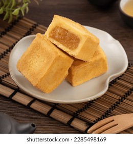 Delicious Taiwanese pineapple cake pastry dessert in a plate on wooden table background with hot tea. - Powered by Shutterstock