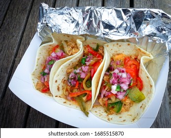 Delicious Takeout Tacos With Chicken, Lettuce, Tomato, And Onions In A Takeout Container