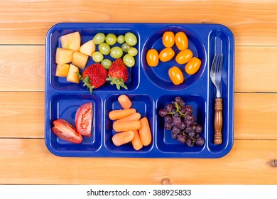 Delicious Tangy And Sweet Fruit Sampler Of Melon, Grapes, Tomatoes, Carrots And Grapes In Lunch Tray With Fork