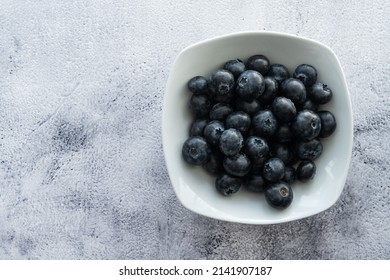 Delicious, tasty blueberries on a rustic background. Still life food photography. Blank space left around the berries for your text.
