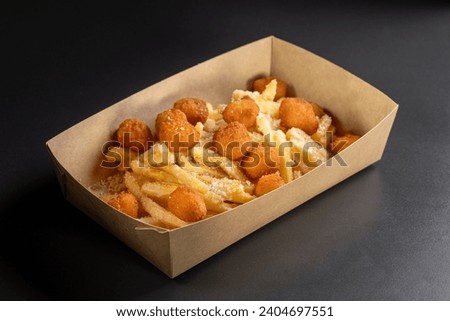 Delicious, tasty french fries topping with Chicken popcorn balls. Deep fry potato or appetizer, fast food. Dish of crisp golden potato chips.