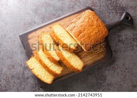 Delicious tender Madeira biscuit cake close-up on a wooden board on the table. horizontal top view from  above
