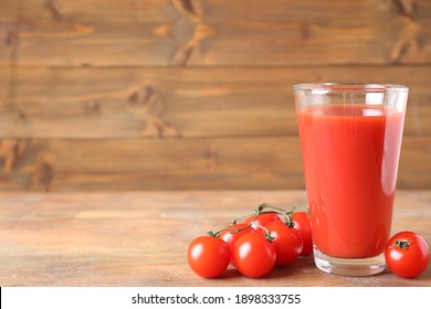 Delicious tomato juice and vegetables on wooden table. Space for text