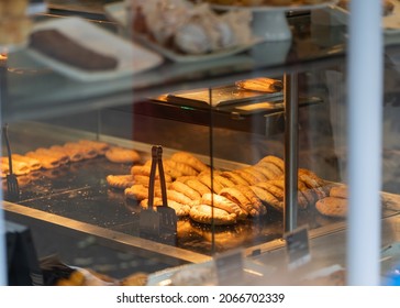 Delicious traditional Cornish pasty pies cooking and on display in shop window. Rows of pasties and pies under heat lamp ready to buy and eat.