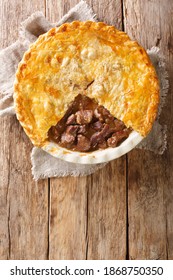 Delicious Traditional English Steak Pie Close-up In A Baking Dish On The Table. Vertical Top View From Above
