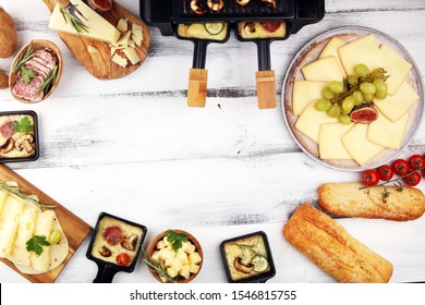 Délicieux raclette traditionnelle suisse fondue sur une pomme de terre cuite ou cuite en dés, servie dans des pastilles individuelles avec du salami et des pommes de terre
