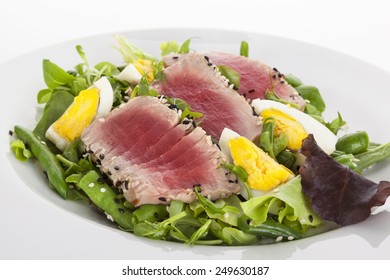 Delicious Tuna Steak With Fresh Green Salad On White Plate Isolated On White Background. Fine Dining.