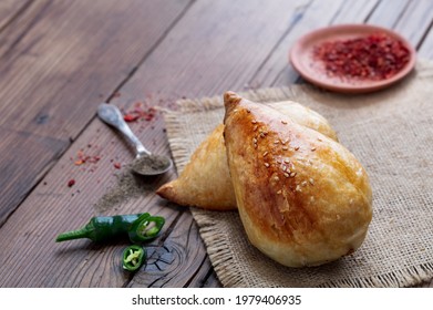 Delicious Uzbek Samsa With Lamb And Spices Cooked In Tandoor On Wooden Background. Uzbek And Central Asia Cuisine Concept.jpg