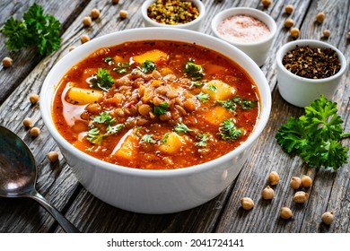 Delicious vege soup - boiled fresh vegetables and  chickpeas on wooden table
					