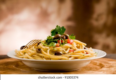 Delicious Vegetarian Dish Of Pasta With Olives And Parsley On Wooden Table