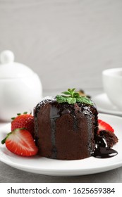 Delicious warm chocolate lava cake with mint and strawberries on table. Space for text - Shutterstock ID 1625659384