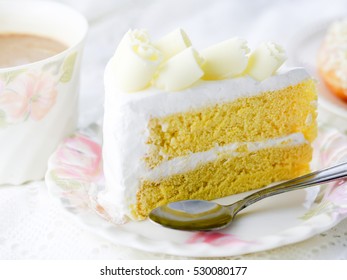 Delicious white chocolate cake and a beautiful cup of tea for wonderful morning in soft blurred background