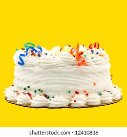 Delicious White Vanilla Birthday Cake With Red, Blue, Green, Yellow And Orange Decorations ~ Isolated On Yellow Background