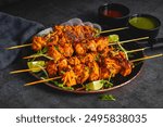 Deliciously Spiced Chicken Tikka Kabab, A Flavourful Grilled Delight with Tangy Marinade and Smoky Charcoal Aroma Serve with Mint and Tomato Chutney. Selective focus. 