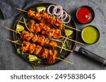 Deliciously Spiced Chicken Tikka Kabab, A Flavourful Grilled Delight with Tangy Marinade and Smoky Charcoal Aroma Serve with Mint and Tomato Chutney. Selective focus. 