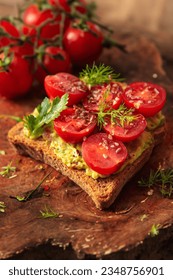 Deliciously topped toast with creamy guacamole and vibrant sliced cherry tomatoes for a refreshing bite. - Shutterstock ID 2348756901