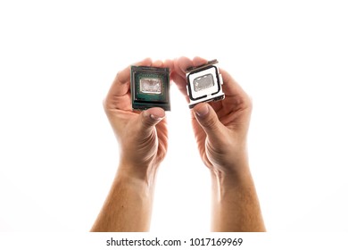 Delidded CPU with old thermal paste and glue in man's hand isolated on white background.