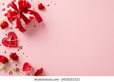 Delight in magic of giving with Valentine's Day ensemble. Top view reveals gift box, red roses, and heart-shaped confetti on pastel pink setting— perfect tableau for your heartfelt sentiments