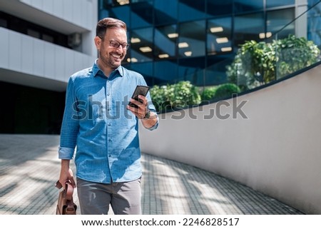 Delighted adult bearded man, excited about the notification he got on his cellphone.