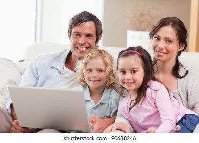 Delighted family using a laptop in a living room