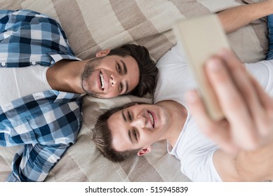 Delighted Gay Couple Making Selfie In Bed