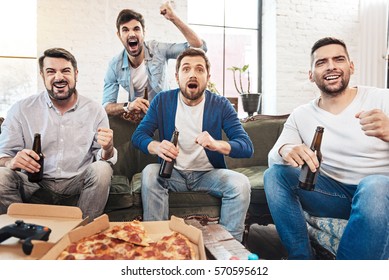 Delighted handsome men being happy for their football team - Shutterstock ID 570595612