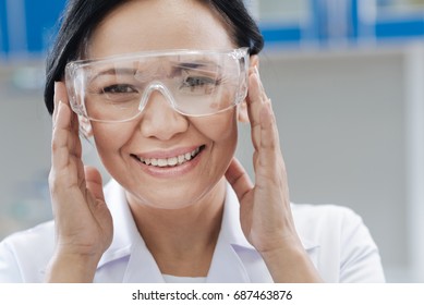 Delighted Laboratory Scientist Fixing Her Protective Glasses