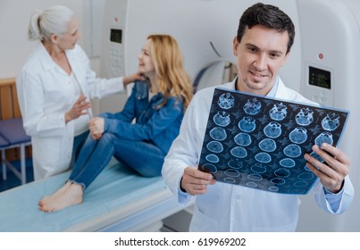 Delighted Positive Doctor Holding CT Scan Results