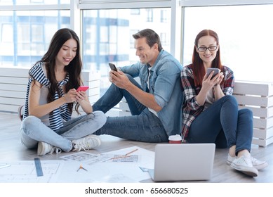 Delighted positive people using their smartphones
