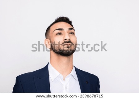 Delighted smart young handsome turkish man in smart ellegant suit standing over grey background in studio isolated. Stock photo © 