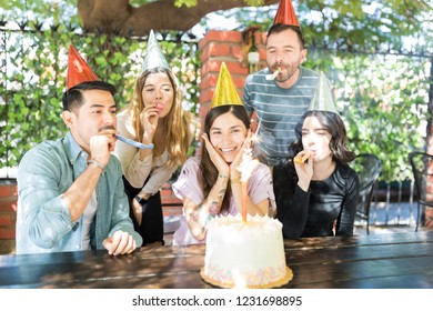 Delighted Woman Enjoying Surprise Birthday Party By Multiethnic Friends At Burger Shop