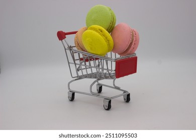 A delightful collection of colorful macarons nestled in a mini shopping cart, showcasing a playful and creative presentation of these sweet treats against a simple background. - Powered by Shutterstock