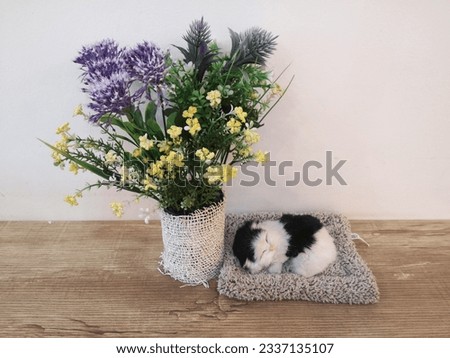 a delightful combination of artificial flowers and miniature lifelike cat replicas, perfect for decorating your tabletops 商業照片 © 