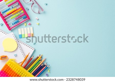 Delightful educational essentials arranged in a top view composition: a vivid assortment of colorful materials on a serene pastel blue background, providing copyspace for text or advertising