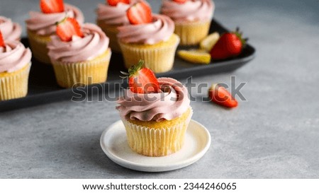 Delightful strawberry cupcakes topped with a luscious whipped cream and garnished with fresh ripe strawberries, creating a harmonious fusion of taste and aesthetics perfect for summer indulgence