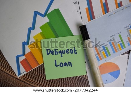 Deliquent Loan write on sticky notes isolated on Wooden Table. Stock market concept