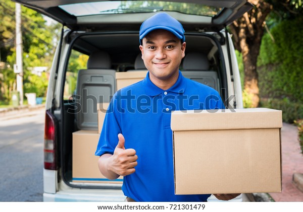 Deliver man\
in blue uniform and parcel cardboard\
box