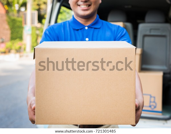 Deliver man\
in blue uniform and parcel cardboard\
box