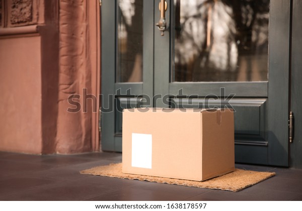 Delivered parcel on door\
mat near entrance