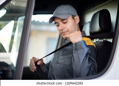 Deliverer Putting On The Safety Belt On His Van