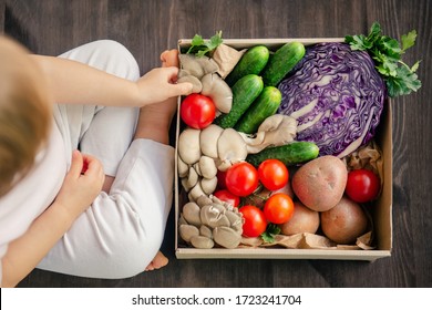 Delivering fresh and healthy vegetables in a paper box for family. Top view of healthy vegetarian food on wood background