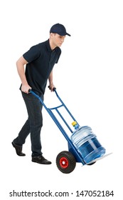 Delivering Water. Cheerful Young Going Carrying A Hand Truck With Water Jug On It While Isolated On White