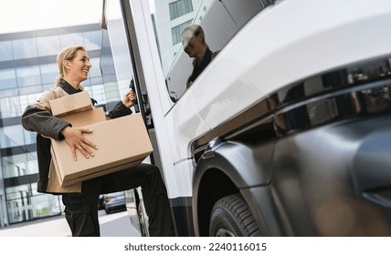 delivery agent holding parcels from a van to deliver it to a customer