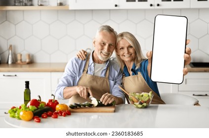 Delivery App. Happy Senior Couple Showing Big Blank Smartphone While Cooking In Kitchen At Home, Smiling Elderly Spouses Recommending New Mobile Application Or Website, Collage, Mockup - Powered by Shutterstock