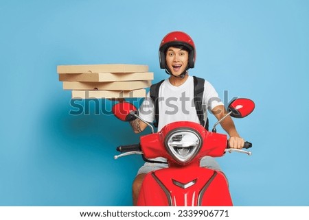  Delivery Asian guy in red helmet riding red scooter holding pizza boxes in one hand, fast delivery concept, copy space